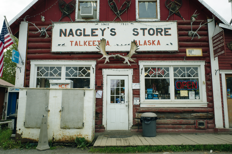 Facade of an old-fashioned red wooden building with sign saying "Nagley's Store"