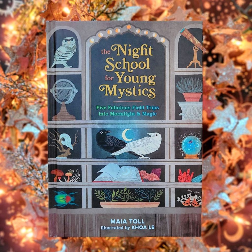 Photo of “The Night School for Young Mystics: Five Fabulous Field Trips into Moonlight & Magic” laid above a softly lit wreath of decorative stars