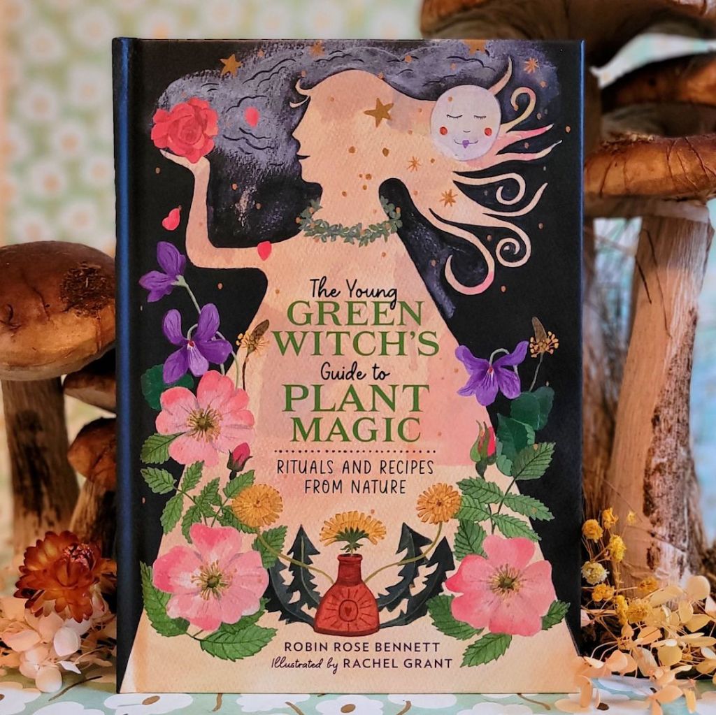 Photo of “The Young Green Witch’s Guide to Plant Magic: Rituals and Recipes from Nature” standing among floral and mushroom decor