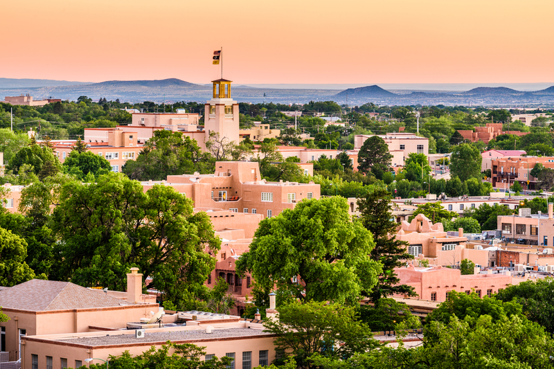 Image of pink adobe buildings and Santa Fe skyline at dusk