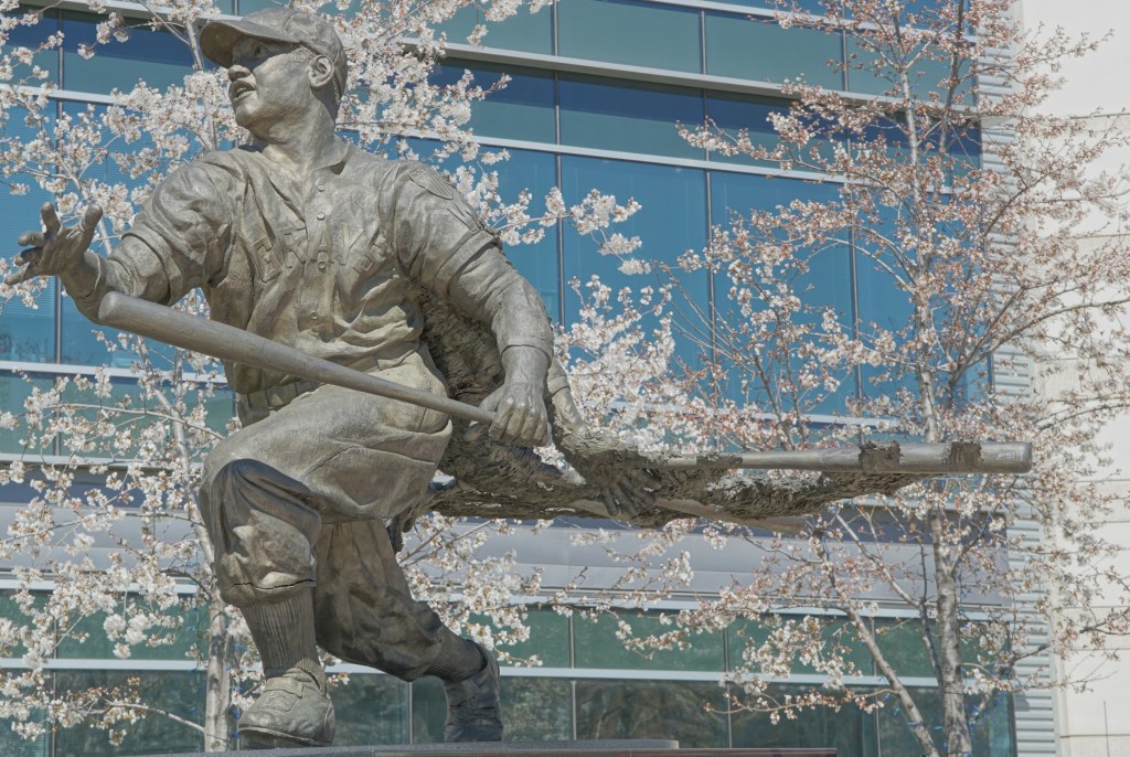 A statue of legendary baseball player Josh Gibson among cherry blossoms