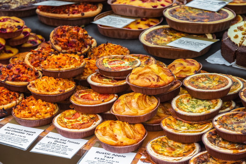 A variety of small tarts piled up in a display case.