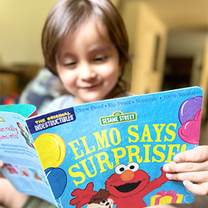 Image of child with Sesame Street book.