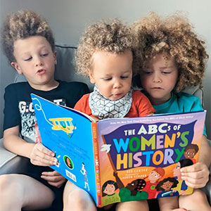 Image of siblings with the ABC's of Women's History book.
