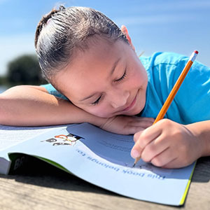 Child, 8-12 years old with a workbook.